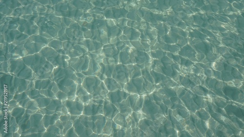 Fondo de agua turquesa y cristalina sobre arena blanca photo