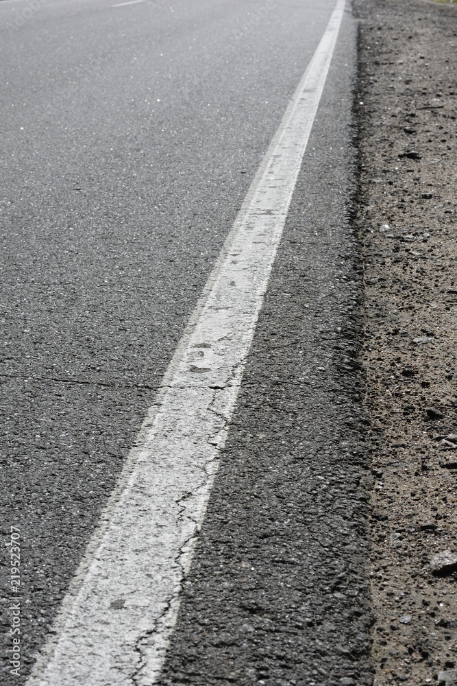 the cracked asphalt on the highway, a continuous strip and a part of a roadside the cracked asphalt on the highway, a continuous strip and a part of a roadside