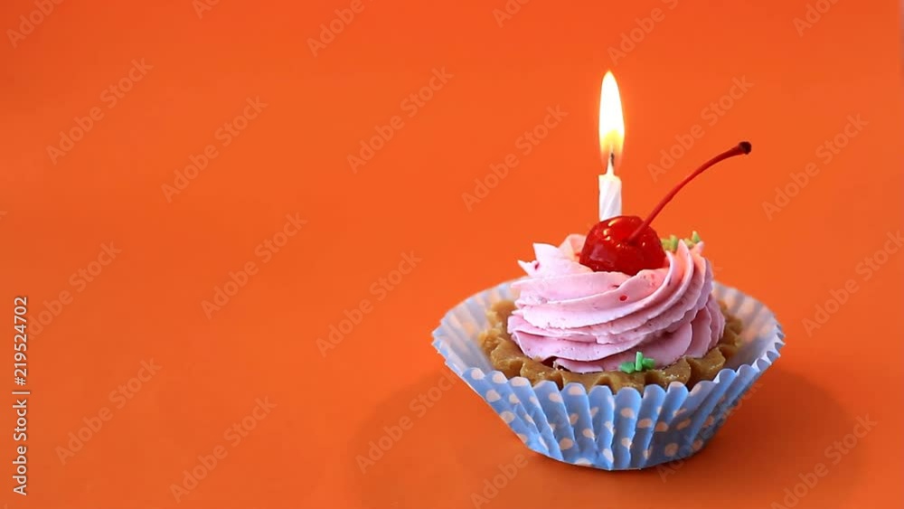 Birthday cake with cherry, pink cream and burning candle for birthday on orange background. Time lapse video Birthday cake with cherry, pink cream and burning candle for birthday on orange background. Time lapse video