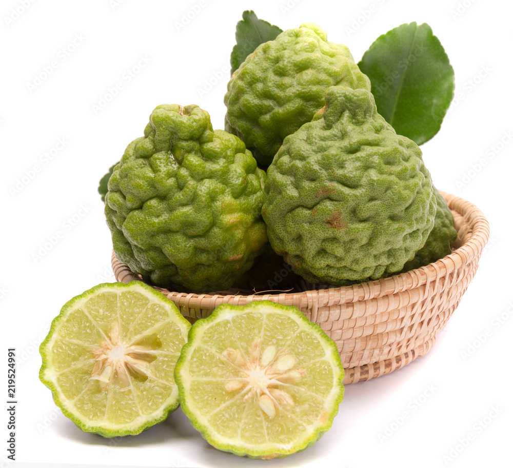 The kaffir lime leaves in the basket on a white background. The kaffir lime leaves in the basket on a white background.