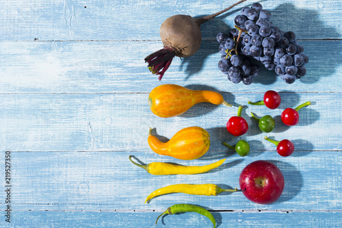 autumn vegetables with shadow on worn blue wood table background