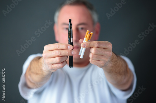 doctor comparing conventional tobacco cigarettes and electronic vaporizer