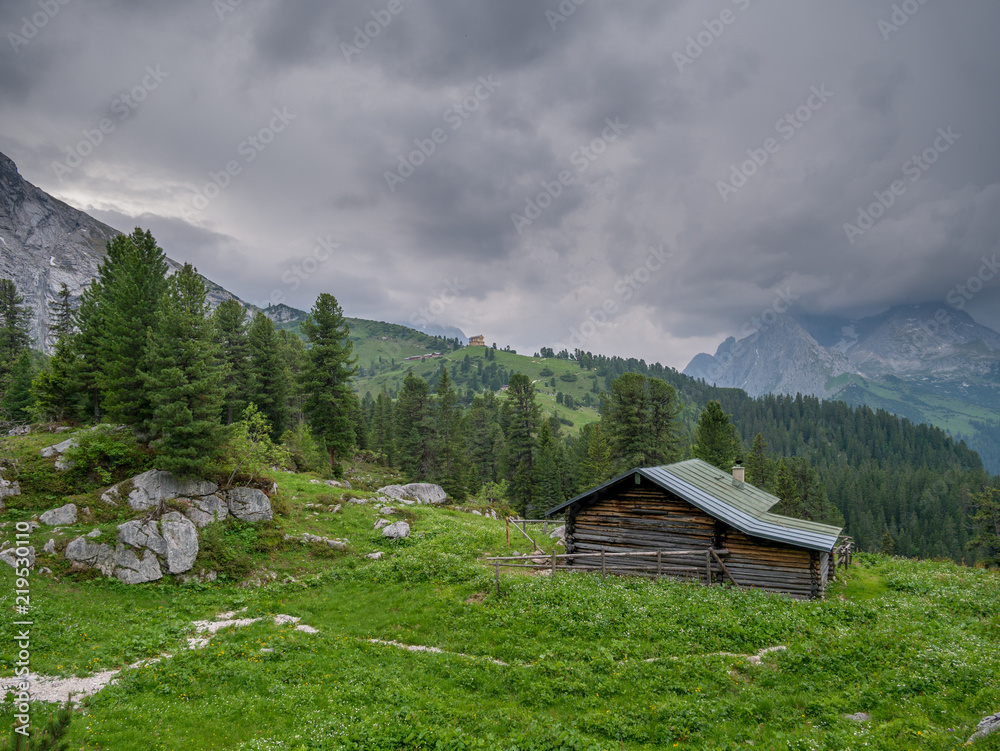 Wooden cabin in the bavarian alps with stormy weather in the background