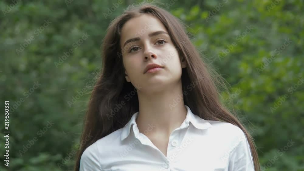 Beautiful girl is walking in the park. A girl with long hair is walking. Beautiful girl is walking in the park. A girl with long hair is walking.