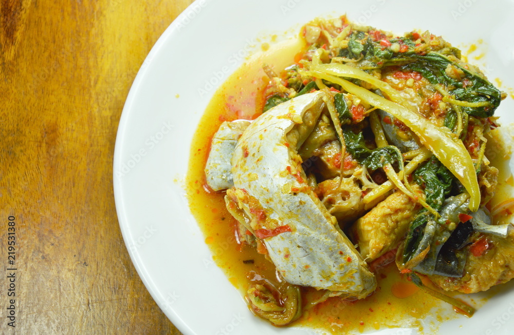 spicy fried striped catfish with herb and curry on plate spicy fried striped catfish with herb and curry on plate