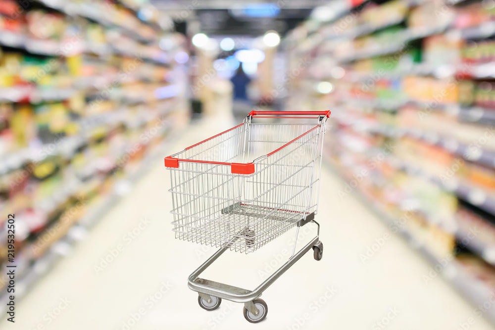 Empty shopping cart with abstract blur supermarket discount store aisle and product shelves interior defocused background Empty shopping cart with abstract blur supermarket discount store aisle and product shelves interior defocused background