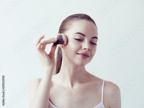Woman makeup powder on face brush 