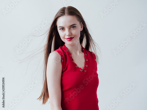 Beautiful woman brunette with long hair in red dress and red lipstick natural portrait