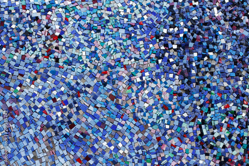 Colorful (blue, white, black, red and purple) stone mosaic tiles on the wall as background or texture
