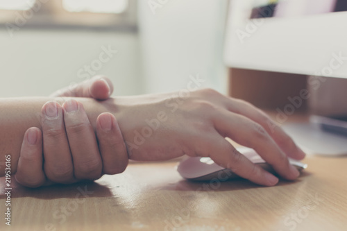 Hand of a businessman with a wrist injury of his own working a computer. Office syndrome concept