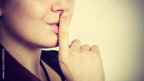 Woman showing silence gesture with finger