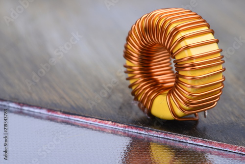 Inductor copper coil on metal background photo