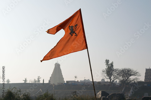 Fototapeta Naklejka Na Ścianę i Meble -  An orange flag with Virupaksha temple in Hampi, India