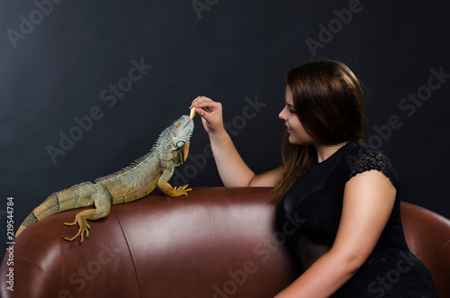 perfect portrait girl and big green iguana in the studio
