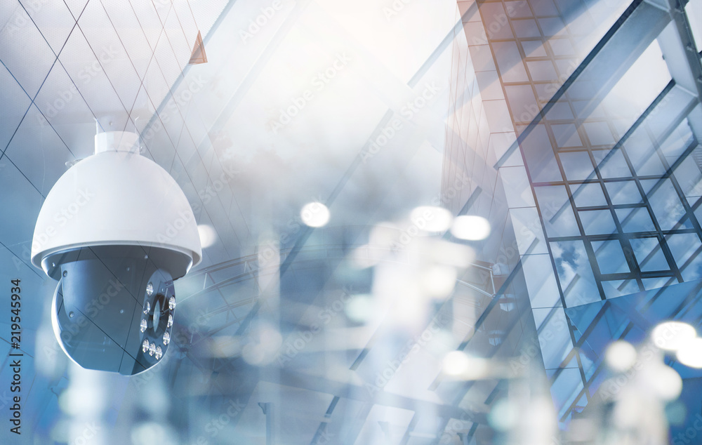 modern CCTV camera on a wall. A foggy day in a city background image