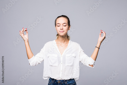 Restful peaceful woman feels relaxed, stands in lotus pose, tries to concentrate or to be focused, closes eyes, enjoys silence, tries to find balance. Calm atmosphere and meditation photo