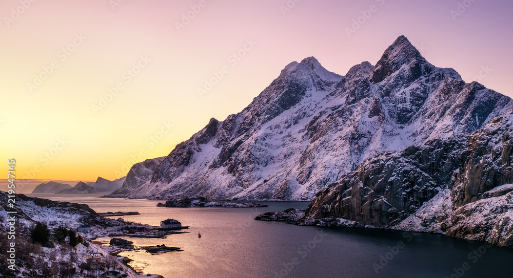 Mountain peak and sea bay during sunrise on the Lofoten islands. Natural landscape in the Norway at the winter time.
