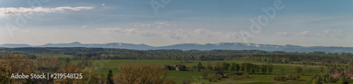 A panoramic photo of the mountain range whita a green foothills photo