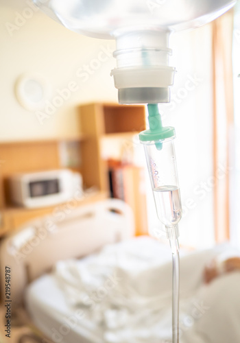 the patient sleeping in hospital bed  with saline intravenous.