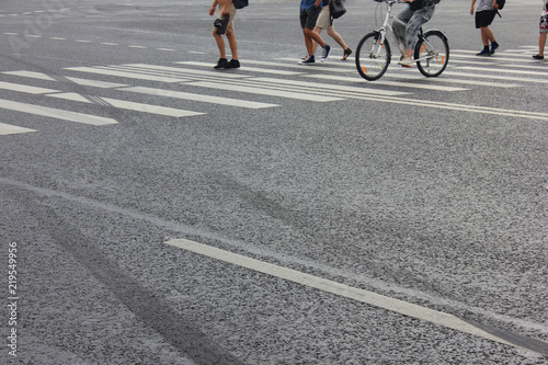 Pedestrians Crossing City Street with White Zebra Lines and Empty Asphalt Road Background. Pedestrian Crosswalk View with People Legs and Bike on City Street, Zebra Crossing Point with Walking People