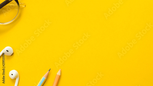 Earphone with colorpencil and grass on yellow background close up business concept copyspace