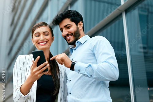 Business People Using Phone Near Office On Street