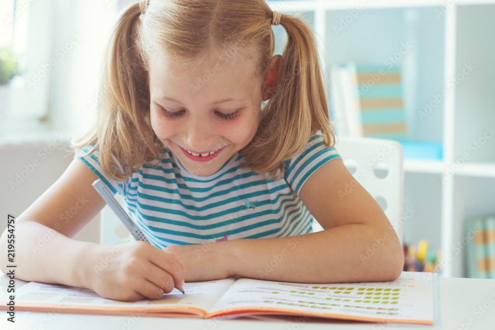 Portrait of schoolgirl at classroom writing at the table Portrait of schoolgirl at classroom writing at the table