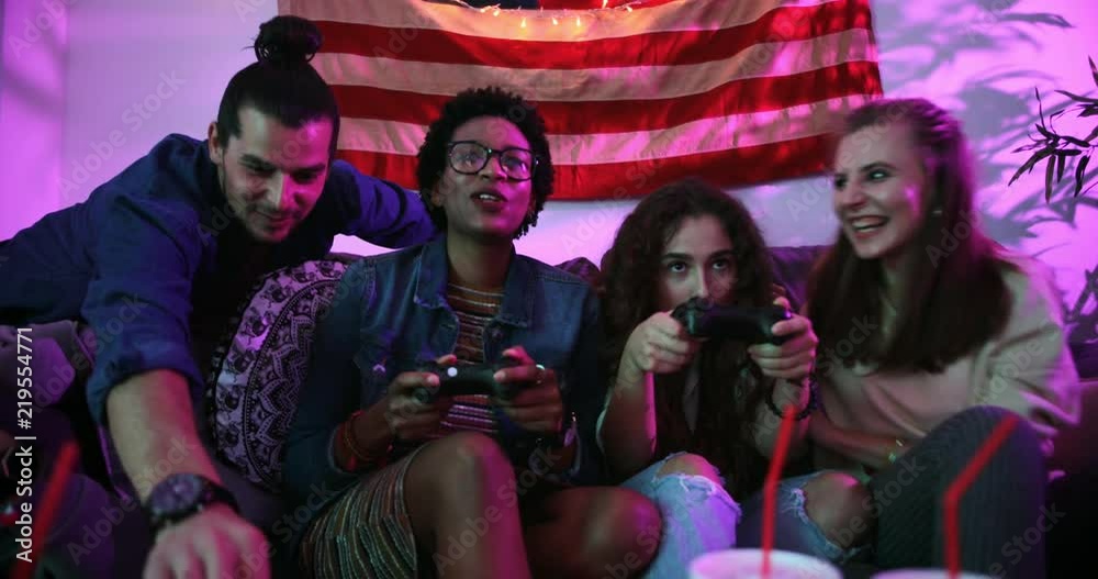 Young multi-ethnic friends playing video games and eating fast food Young multi-ethnic friends playing video games and eating fast food