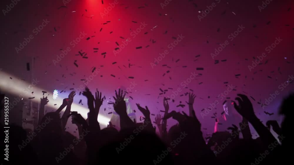 A crowd of people dancing at a music festival. A party in the big hall