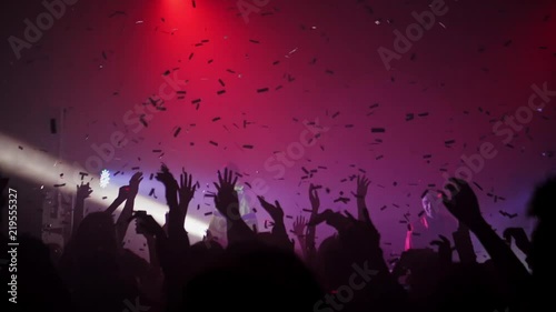 A crowd of people dancing at a music festival. A party in the big hall