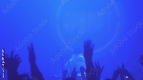 A crowd of people dancing at a music festival. A party in the big hall