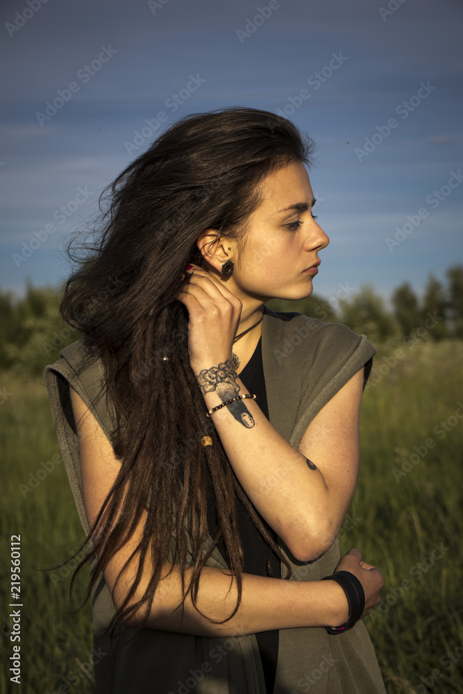 beautiful young girl in jacket lying down on grass