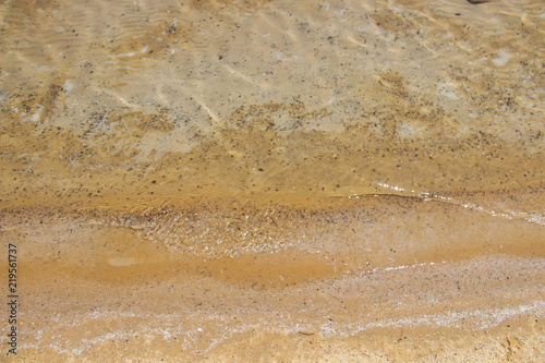 Background Brown sand through the clear waters of the dead sea