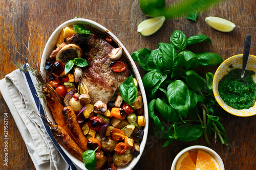 Healthy beef meat baked vegetables ceramic pot wooden table sauce top view