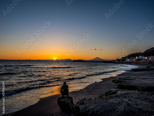 Mt. Fuji from the seaside at dusk. The mountain in the back is Mt. Fuji in Japan.The beachfront is very beautiful. In addition, the sunset is also very beautiful.