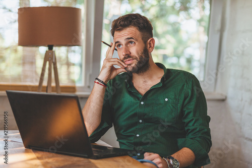 Young man having sressful time working on laptop