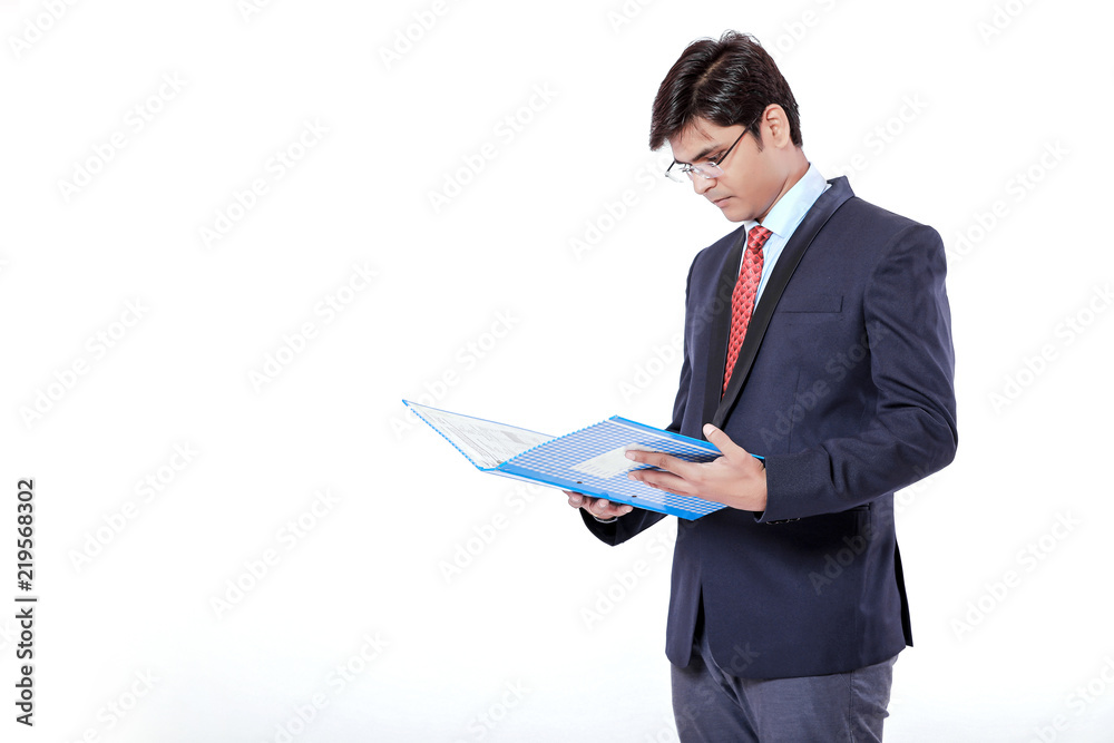 Young Indian businessman holding document file over white background Young Indian businessman holding document file over white background