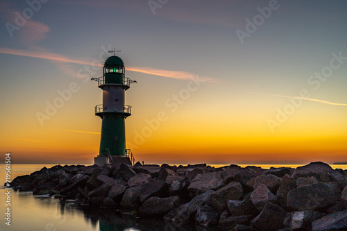 The entrance to a harbor with lighthouse at beautiful sunset