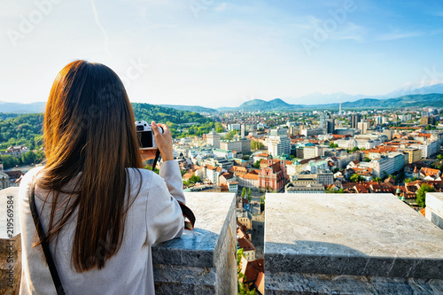 Fototapeta Naklejka Na Ścianę i Meble -  Girl taking photos of panoramic view of Ljubljana Slovenia
