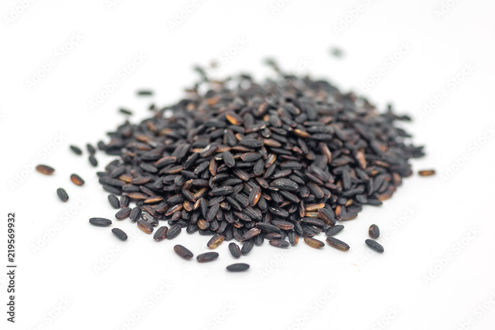 Uncooked black rice against a white background, with a shallow depth of field Uncooked black rice against a white background, with a shallow depth of field