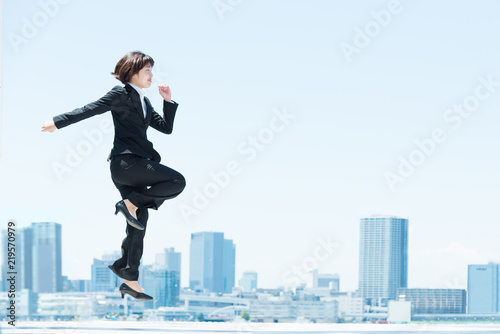 勢い良くジャンプする女性（ビジネスイメージ）