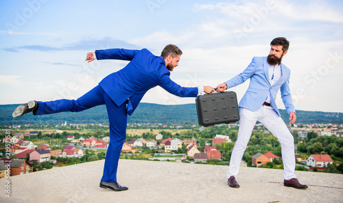 Men suits handover briefcase. Business deal landscape background. Businessman takes away briefcase from business partner. Fraud and extortion concept. Rascal racketeer extortionist cheating handover