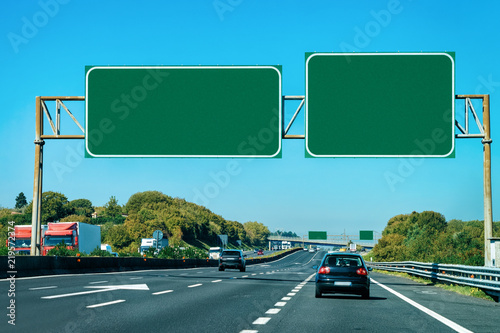 Car and empty green traffic signs on road in Italy