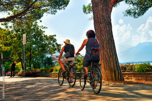 Couple riding bicycle embankment of Geneva Lake Montreux Riviera