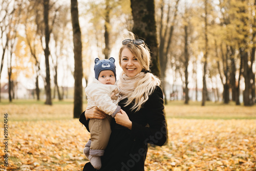 Portrait of a young mother with her baby in the autumn Park. © ksyusha_yanovich