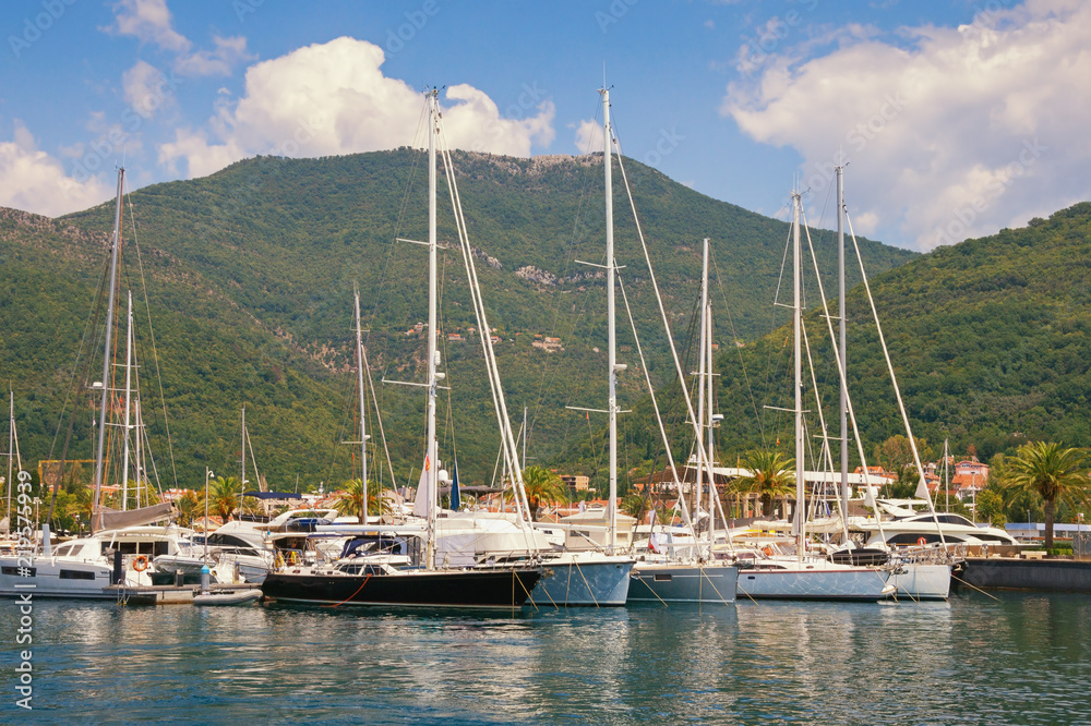 Yachts on the water against the background of the mountains.  View of yacht marina of Porto Montenegro. Montenegro, Bay of Kotor, Adriatic Sea, Tivat city