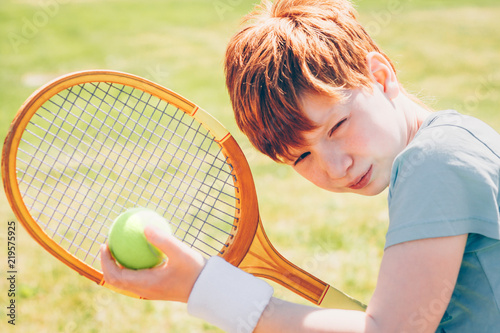 Young red-haired tennis player is determined to win photo