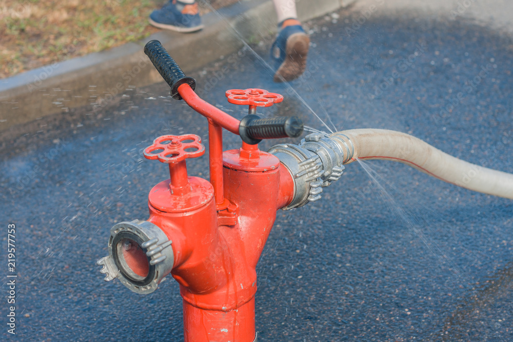 Damaged fire hose from a fire hydrant - water spray Damaged fire hose from a fire hydrant - water spray