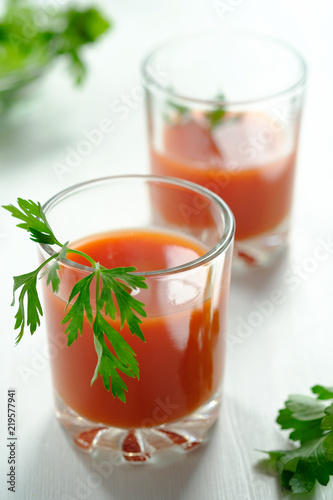 A glass of fresh tomato juice and tomatoes, parsley