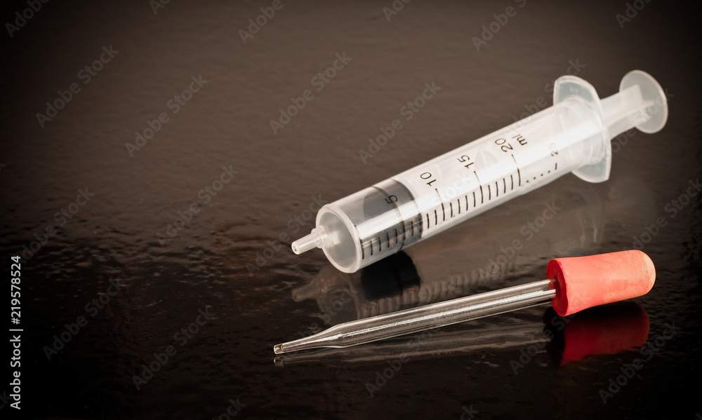 Pipette and Syringe science laboratory equipment on black table. Pipette and Syringe science laboratory equipment on black table.